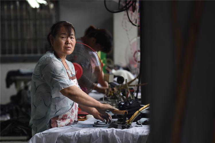 2019年7月,郸城县汲冢镇谢楼行政村扶贫服装加工厂,女工们正在车间